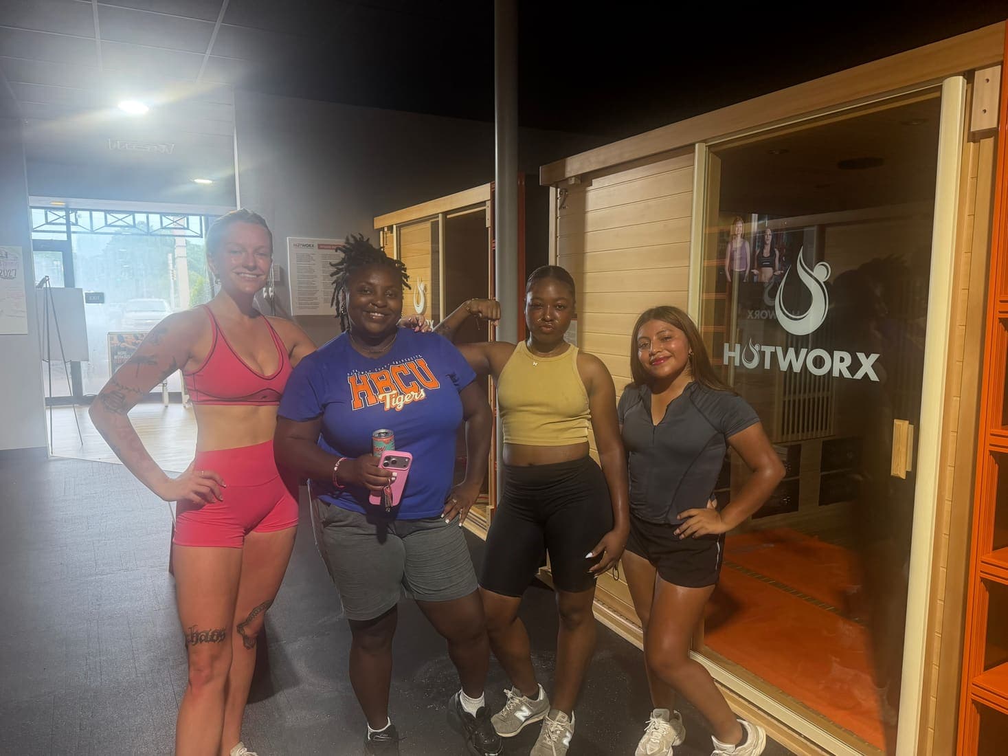 Four team members outside a fitness studio after a workout